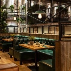 a restaurant with green leather booths and wooden tables