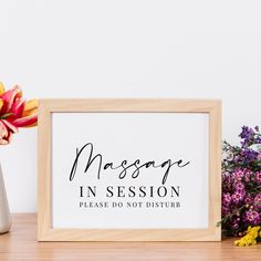 a sign that says massage in session, please do not disturb with flowers next to it