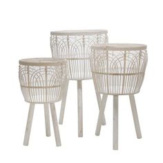 three white planters sitting next to each other on top of wooden legs with wicker baskets