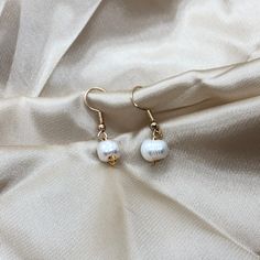 This is an elegant, minimalist , Pearl earring. These earrings are a great gift for anyone or a piece to level up your collection! -DETAILS- - Ivory Freshwater Pearl  - Gold colour hardware - Water resistant  -CARE-  - To avoid extreme tarnishing reduce contact with lotions, oils, and fragrances  - No abrasive materials should come in contact with the piece  - To clean simply fill a bowl with some soapy water do a cloth into the water and wipe  - If you need any repairs feel free to message us -SHIPPING- - We ship all of our orders with regular letter mail  - All of our orders are packaged with love and care -QUESTIONS- - If you have any questions or concerns feel free to message us  - If you want an order specially packaged you can message with requirements  - You can always personalize y Elegant White Everyday Earrings, Everyday Pearl White Drop Earrings, Pearl White Drop Earrings For Everyday Wear, Minimalist Pearl Drop Earrings In Pearl White, Pearl White Dangle Earrings For Everyday, Handmade Minimalist White Pearl Earrings, Handmade White Minimalist Pearl Earrings, Everyday Drop Earrings With Pearl Charm, Minimalist Handmade White Pearl Earrings