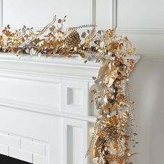 a gold and silver garland is hanging on the mantle in front of a fire place