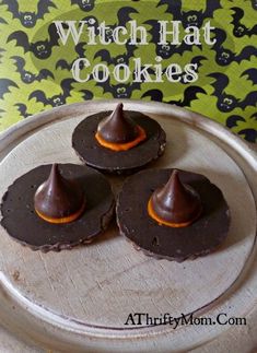 three chocolate desserts on a metal tray next to a green and black wallpaper