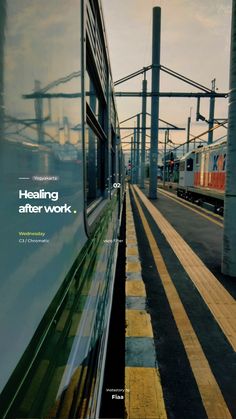 the train is traveling down the tracks next to the platform with its reflection in the window