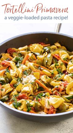 a pan filled with pasta and vegetables on top of a table