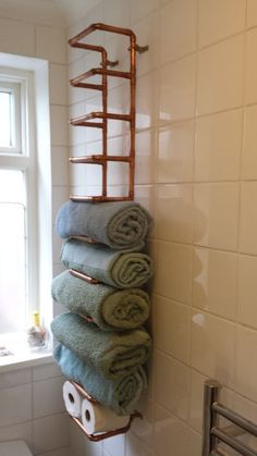 towels are stacked on the rack in this bathroom