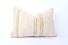 a white and tan striped pillow on a white background