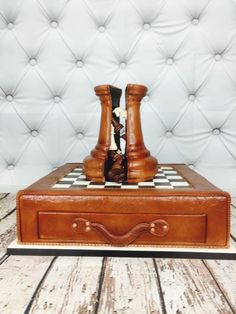 a chess board on top of a brown leather case with two pieces in the middle