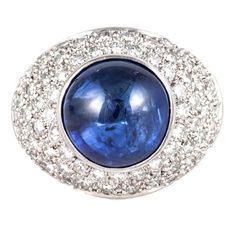 Estate 'Boodles' ring in 18K white gold ring featuring a cabochon blue sapphire with round brilliant-cut diamonds. There are 72 round diamonds that total 1.50 carats, G-H color and VS clarity. The cabochon blue sapphire is 8.40 carats. The presentation area of the ring measures 3/4 of an inch by 5/8 of an inch. It is a size 6 1/4. Marked "Boodles B & D 750" on the inside. Blue Sapphire Jewelry, Sapphire Cocktail Ring, Diamond Gold Ring, Garnet And Diamond Ring, Diamond Cocktail Rings, Sapphire Diamond Ring, White Gold Earrings, Domed Ring, Women Diamond