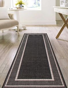 a black and white runner rug on the floor in front of a table with a chair