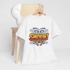 Turn up the heat with our 'Smokin' T-Shirt, inspired by a classic catchphrase from a beloved 90s comedy! This tee is a must-have for fans of retro movies and iconic pop culture quotes. Made with premium, soft cotton, this shirt is perfect for everyday wear or as a standout piece in your collection. The bold design and striking typography make it a great conversation starter, while the comfortable fit ensures you can wear it all day with ease. Whether you're a movie buff, a lover of 90s nostalgia Pop Culture Quotes, Retro Movies, Retro Pop Culture, Culture Quotes, Retro Pop, Quote Tees, Movie Buff, Catch Phrase, 90s Nostalgia