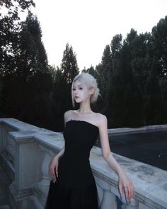 a woman with white hair wearing a black dress