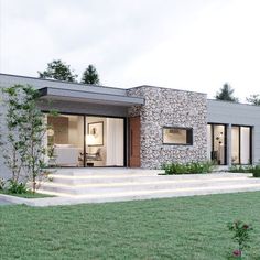 a modern house with stone walls and steps leading up to the front door