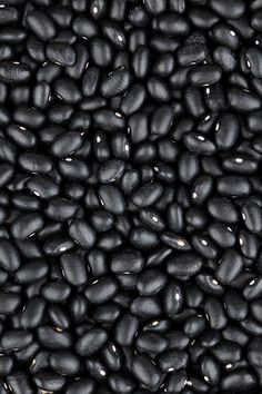 a pile of black beans sitting next to each other