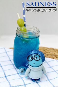 a blue drink sitting on top of a table next to a small toy figurine