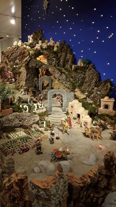 a display in a store filled with lots of fake rocks and plants on top of a hill