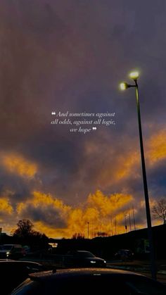 a street light sitting next to a parking lot under a cloudy sky