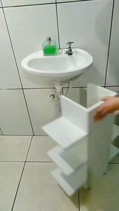 a white sink sitting next to a toilet under a faucet in a bathroom