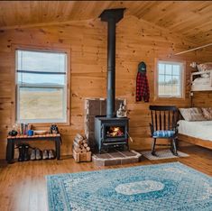 a bedroom with wood paneling and a stove in the corner, next to a bed