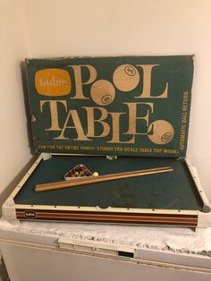 an old pool table with cues, cues and balls in it sitting on top of a chest