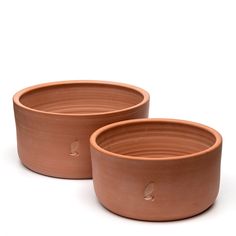 two clay bowls sitting next to each other