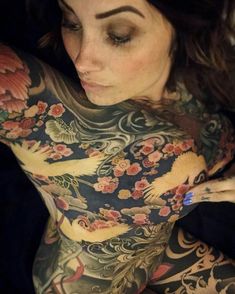 a woman with tattoos on her chest and arms