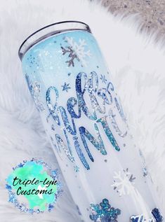 a blue and white tumbler with snowflakes on it that says merry christmas