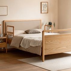 a bedroom with a bed, nightstands and pictures on the wall above it in neutral colors