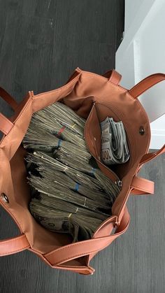 a brown bag filled with money sitting on top of a wooden floor next to a white door