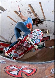 a person on a skateboard in the air above a ramp with graffiti painted on it