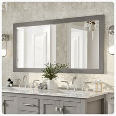 a bathroom with two sinks and a large mirror over it's counter top area