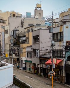 a city street with lots of buildings and power lines above the streets in front of them