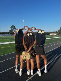 three girls standing in the middle of a track with their hands on their hipss