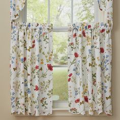 a window with floral curtains in front of it