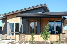 a house that is made out of wood and has windows on each side, along with stone steps leading up to the front door