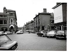 an old black and white photo of cars parked on the street