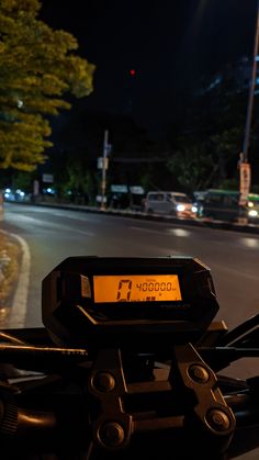 a close up of a speedometer on the handlebars of a motorcycle at night