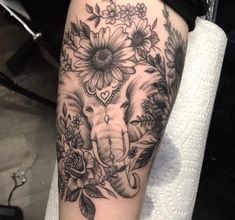 an elephant and flowers tattoo on the arm