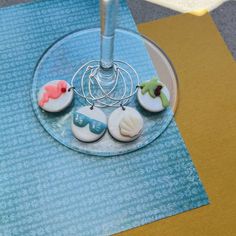 four decorated cookies sitting on top of a glass plate with a wire rack in the middle