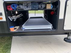 the back end of a camper with an open door and storage area in it