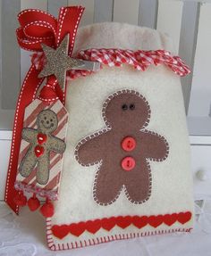 a white bag with a red ribbon around it and a gingerbread man on the front