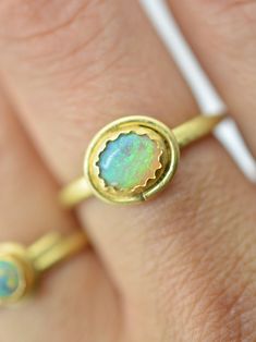 The flash within this beautiful Australian opal from the Lightening Ridge mine is reminiscent of fireflies dancing over a glowing meadow. I love the sparkling blue and green hues of this stone that reveal an incredible rainbow of warm sunrise colours when the light dances over it. One of a kind, this ring features a hand-forged 18k solid gold ring shank and a glowing 22k yellow gold bezel. Materials: Australian Lightening Ridge opal, 18k and 22k yellow gold Size 7.5 This one of a kind ring canno Unique Oval Opal Birthstone Ring, Green Opal Cabochon Ring, Fine Jewelry Green Opal Ring, Unique Green Opal Ring, Petal Ring, Sunrise Colors, Heirloom Rings, Ring Shank, Turquoise And Coral