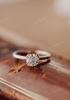 a diamond ring sitting on top of an old book