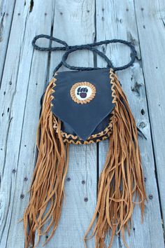 This beaded bear paw handbag is made in black leather with saddle tan lace. The measurements are 7.5 inches x 6 inches x 1.5 inches. This beaded bear paw bag has fringe down the sides , front and back. The 4 point braided shoulder strap measures 48 inches. This leather handbag has a beaded bear paw on the front flap and an extra pocket inside. Ready to ship Leather Mobile Phone Bag For Festivals, Black Shoulder Bag With Cell Phone Pocket For Festivals, Brown Bags With Bear Design For Everyday Use, Brown Bear Design Bags For Everyday Use, Small Leather Phone Bag, Beaded Bear Paw, Beaded Bear, Leather Top Hat, Leather Medicine Bag