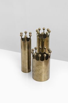 three brass vases sitting on top of a white table