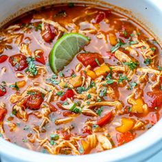 a white bowl filled with chicken tortilla soup and garnished with cilantro