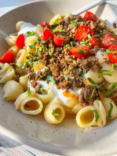 a bowl filled with pasta and meat on top of a table