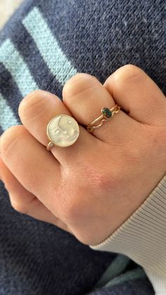 15mm white or natural mother of pearl disc engraved with a crescent moon and star.  Rings are handmade using gold filled or sterling silver components.   Please be sure to properly measure for your ring size as these rings are custom-made and are not eligible for exchange or return.   Get the matching pendant here: https://www.etsy.com/jacknginger/listing/1073393095/luna-mother-of-pearl-celestial-pendant?utm_source=Copy&utm_medium=ListingManager&utm_campaign=Share&utm_term=so.lmsm&share_time=1629846600328 You may purchase a ring sizer here: https://www.etsy.com/listing/863119713/ring-sizer Celestial Style Opal Ring, White Round Sun And Moon Design Jewelry, 14k Gold Celestial Opal Ring, Celestial 14k Gold Opal Ring, Celestial Yellow Gold Round Opal Ring, Celestial Yellow Gold Opal Ring, 14k Gold Moon Phase Rings As Gift, 14k Gold Rings With Moon Phase For Gift, Handmade White Signet Ring