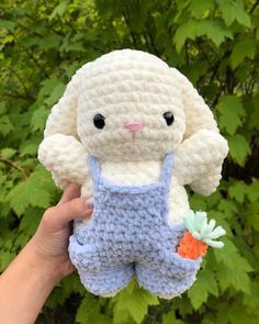 a crocheted bunny holding a carrot in its hand