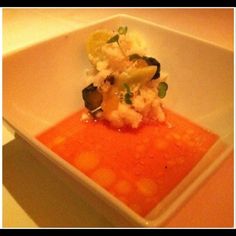 a white bowl filled with food and garnished in sauce on top of a table