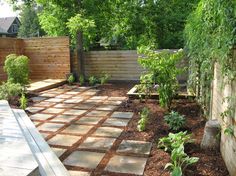 a backyard garden with brick walkways and trees